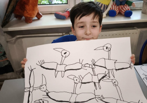 Chłpiec z bocianami narysowanymi mazakiem