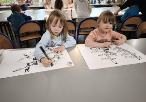 Dziewczynki rysują mazkaiem kontury bocianów