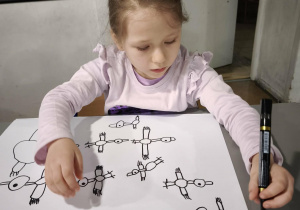 Dziewczynka ryzuje kontury bociana