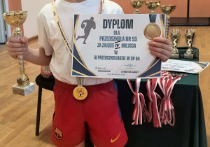 Chłopiec z dyplomem i pucharem