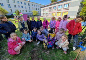 Dzieci z posadzonym krzewem forsycji