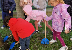 Dzieci z grabiami w ogrodzie