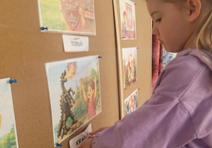 Dziewczynka pzyczepia napis Kraków