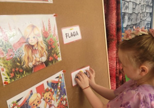 Dziewczynka przyczepia napis hymn