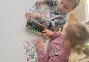 Chłopiec z dizewczynką kolorują ilustrację