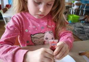 Dziewczynka dekoruje flagę jadalnymi flamastrami