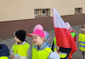 Dziewczynka trzyma planszę z informacjami o pierwszym maja